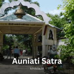 Entrance of Auniati Satra, a historic Vaishnavite monastery in Assam, surrounded by greenery and featuring traditional Assamese architectural elements.
