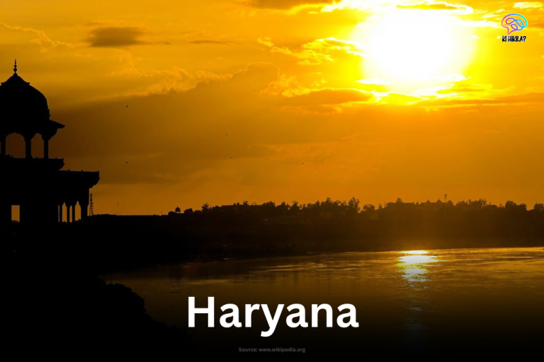 Sunset over the Yamuna River with a traditional pavilion silhouette in Haryana.