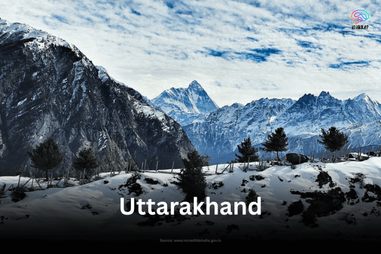 The snow-covered slopes of Auli, Uttarakhand, with a majestic view of the Himalayan peaks under a vast, cloudy sky.
