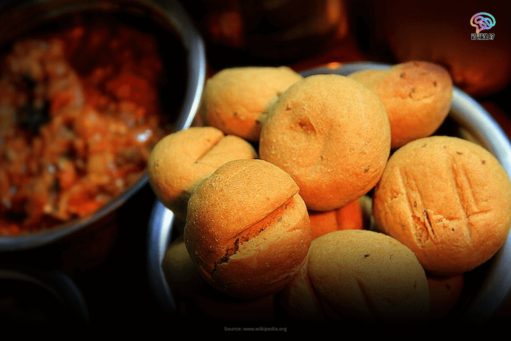 Rajasthan State Guide: Majestic Forts, Rich Heritage, and Key Facts for Students and Curious Minds A close-up of Dal Bati Choorma, a traditional Rajasthani dish, featuring several round, baked batis in a bowl next to a serving of dal.