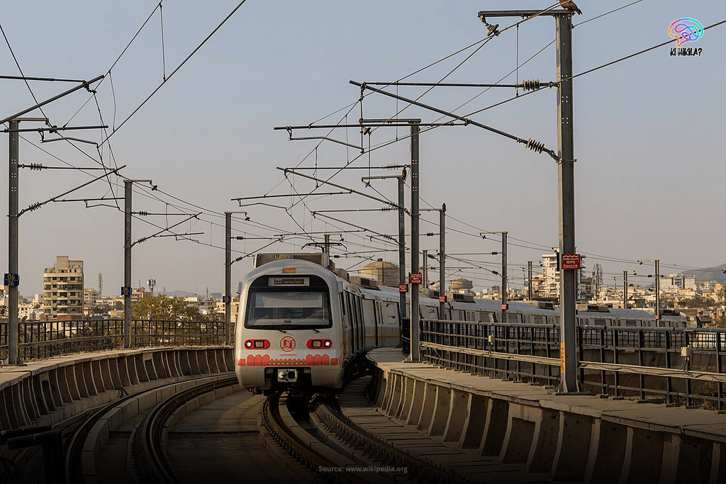 Rajasthan State Guide: Majestic Forts, Rich Heritage, and Key Facts for Students and Curious Minds A modern Jaipur Metro train moving on elevated tracks with the city skyline in the background, illustrating urban transportation in Rajasthan.