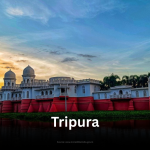 The magnificent Neermahal palace, with its white domes and red base, reflecting on the tranquil Rudrasagar Lake in Tripura at sunset.