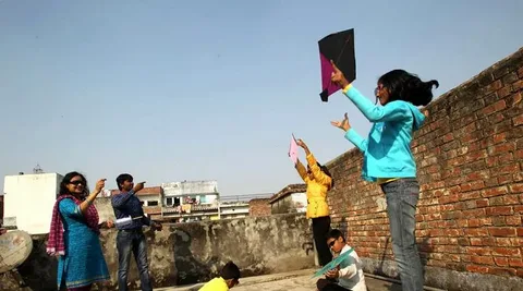 Karka Sankranti Fastival: A Sacred Transition of the Sun into Cancer Zodiac Children and adults flying kites on a rooftop during the Karka Sankranti Festival celebration.
