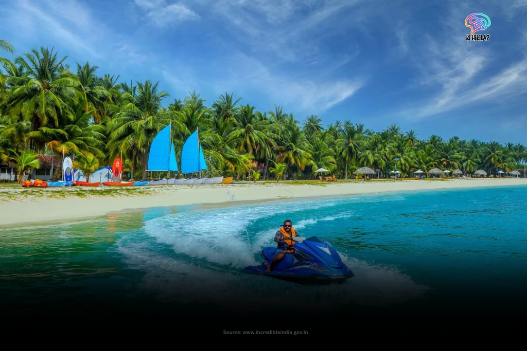 Lakshadweep: A Complete Guide to India’s Coral Paradise, Culture, and Islands A person riding a jet ski in the turquoise waters off a white sand beach lined with palm trees in Lakshadweep.