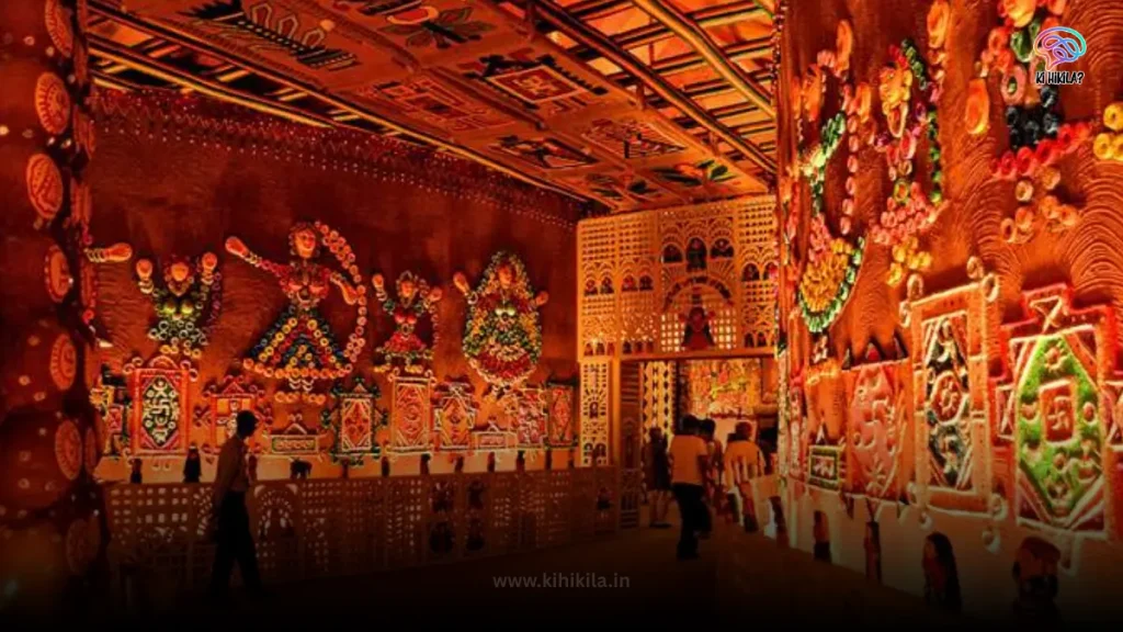 The interior of a Durga Puja 2025 pandal with intricate, handcrafted folk art on the walls and ceiling.