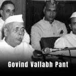 Govind Vallabh Pant: A vintage black-and-white photo of a man in a suit and turban, speaking at a podium.