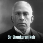 Sir Shankaran Nair: A vintage black-and-white photo of a man in a suit and turban, standing with a book in hand.