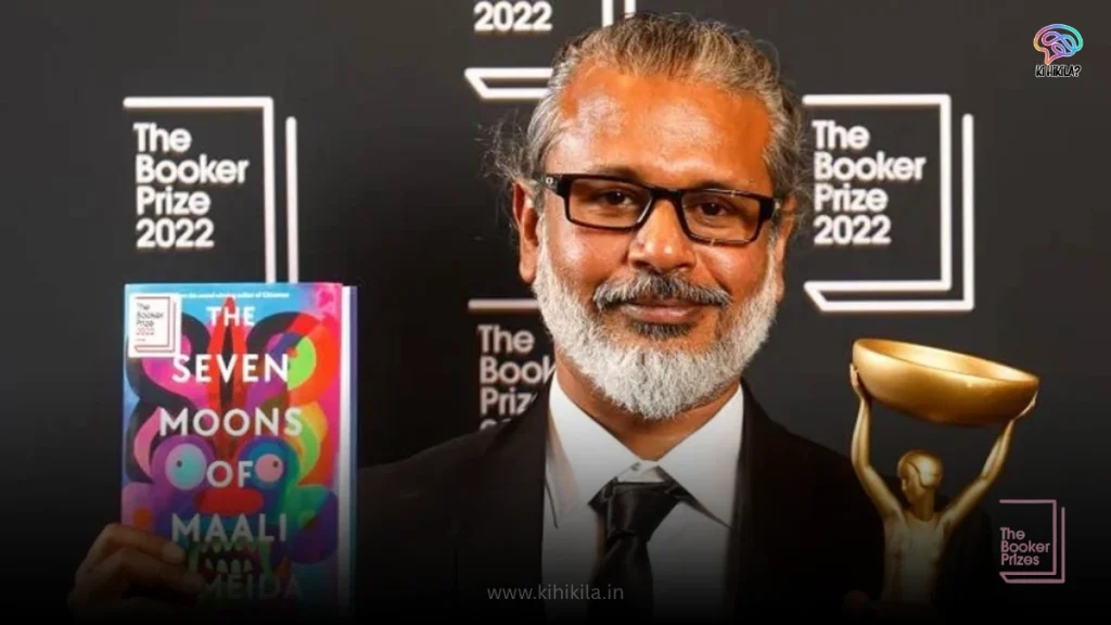 Author Shehan Karunatilaka holding his winning book, "The Seven Moons of Maali Almeida," and the Booker Prize trophy.